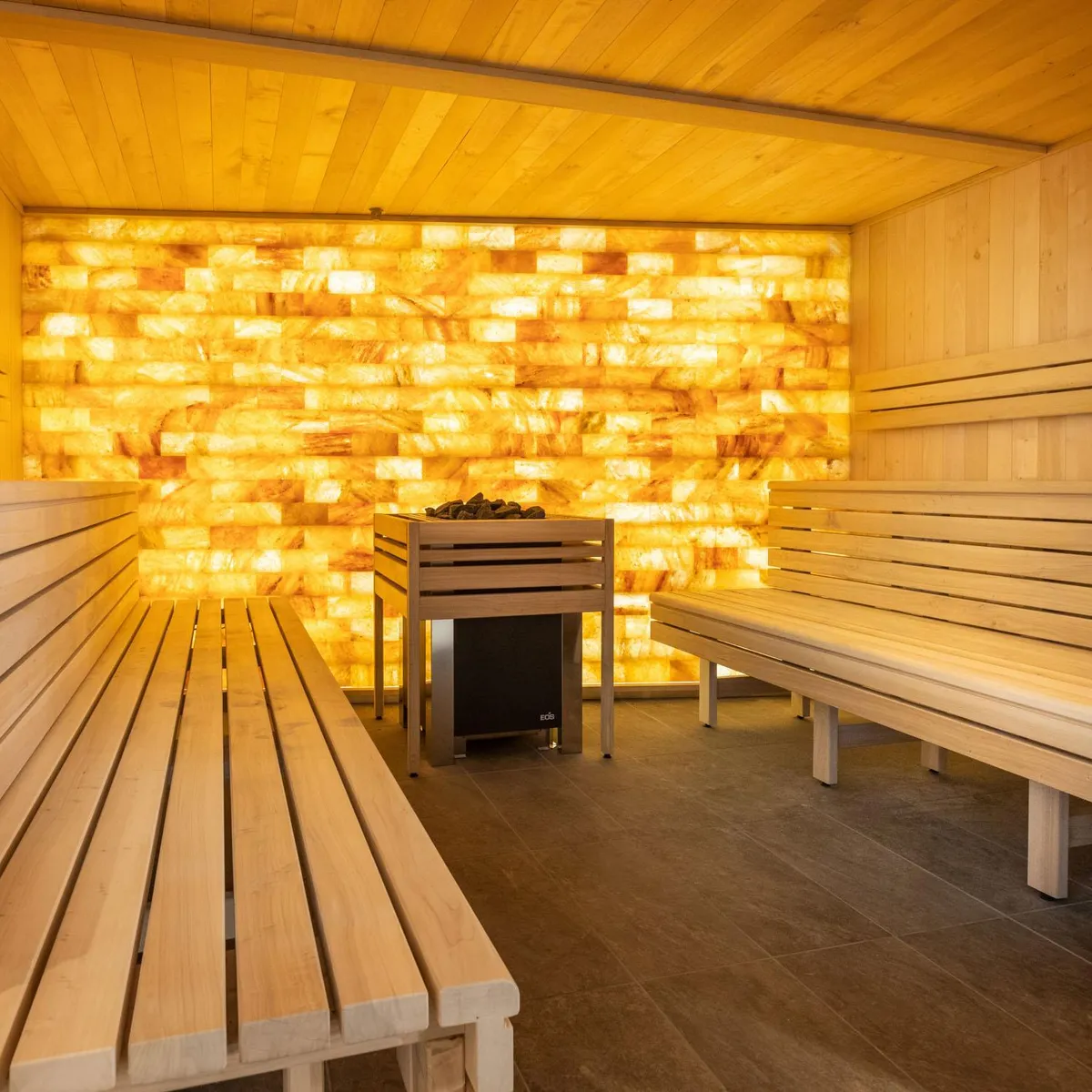 Salle en bois avec des bancs et un mur éclairé par des motifs lumineux