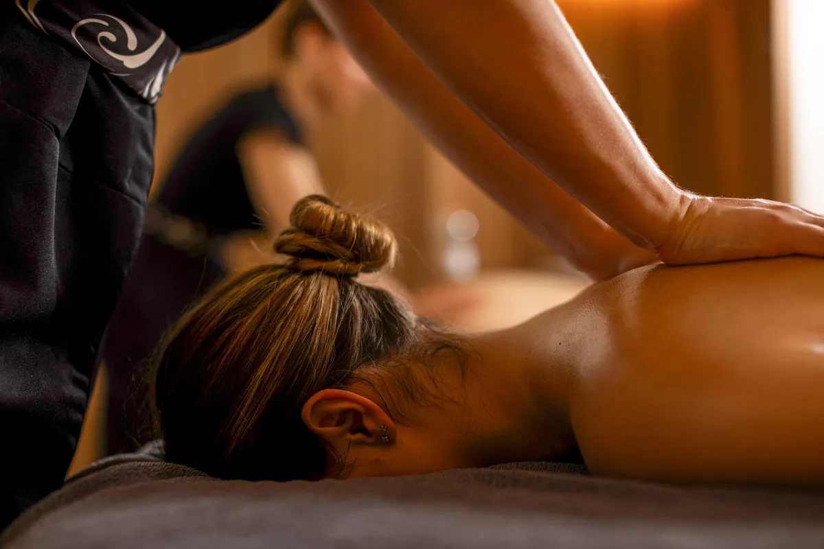 Une personne allongée sur le ventre reçoit un massage dans un cadre professionnel