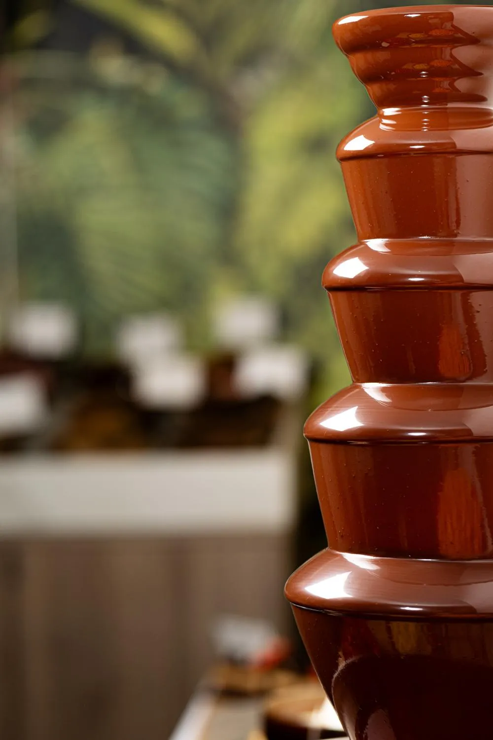 Une série de pots en terre cuite empilés devant un fond flou de végétation et de structures en pierre
